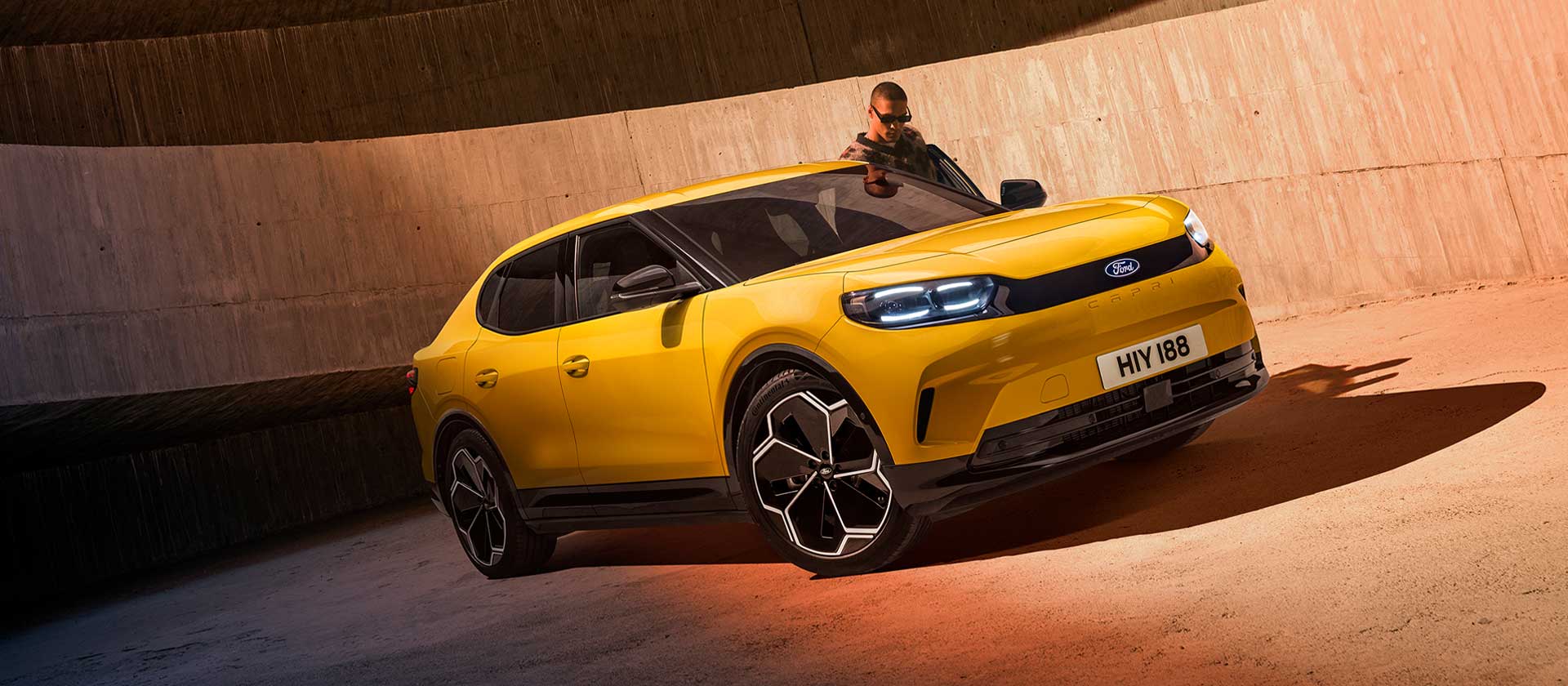 Un nuovo SUV Ford Capri® completamente elettrico giallo posteggiato in un parcheggio.