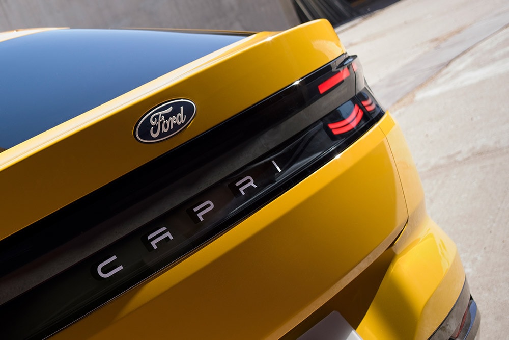 Vista ravvicinata della scritta «Capri» sul retro di un nuovo SUV Ford Capri® completamente elettrico giallo. 